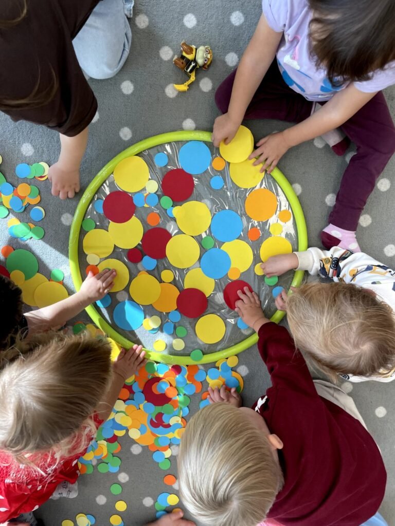 Dzieci podczas zabawy sensorycznej z kolorowymi kulkami w zlobku na Goclawku